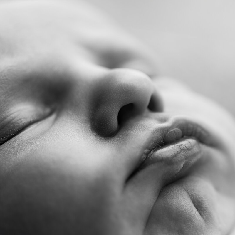 Capturing the delicate features of a newborn’s face, this close-up image is a timeless reflection of love’s tiniest details.
