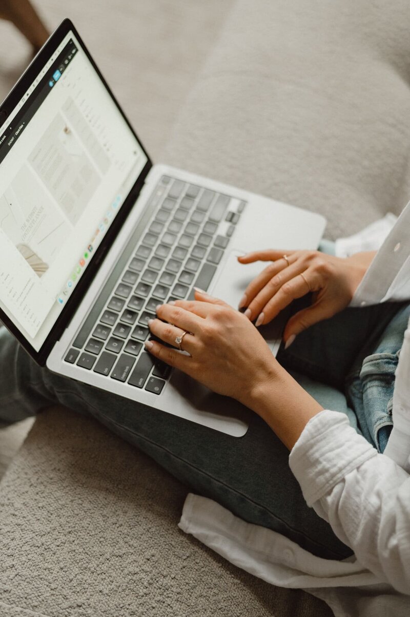 Closeup of web designer typing on a laptop, building results-driven websites for wellness brands