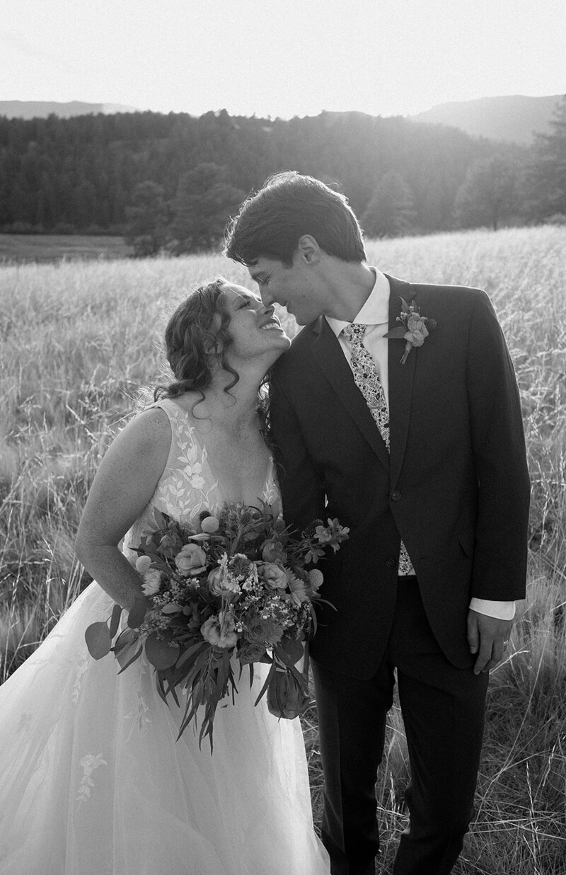 bride and groom go in for a kiss at sunset in Colorado at Deer Creek Valley Ranch wedding venue