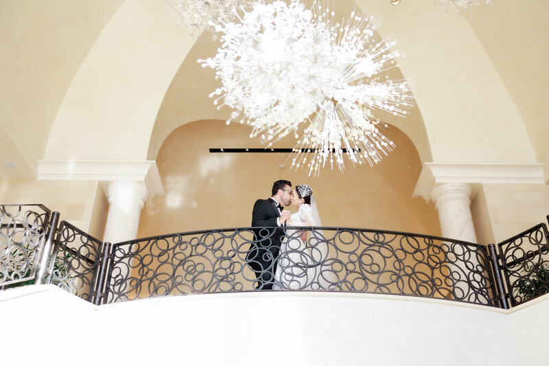 Bride and groom portrait on the grand staircase at a wedding at the four seasons Orlando by Florida wedding photographer.