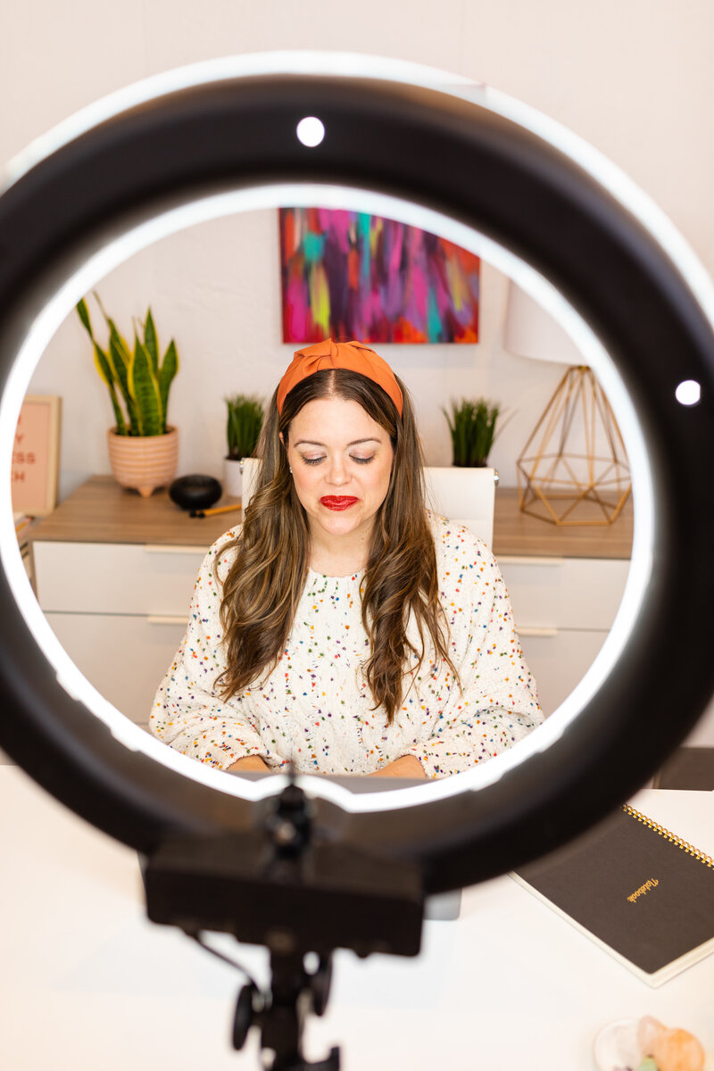 heather sitting at desk in front of ring light