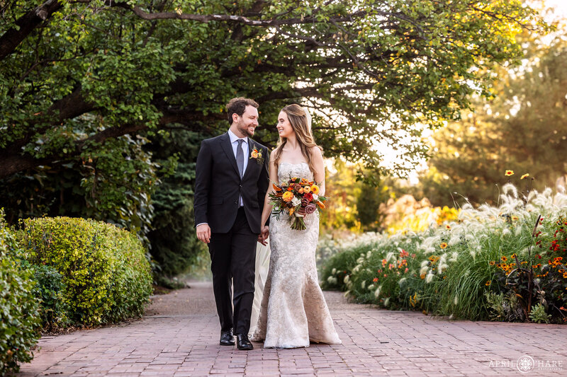 Couple walk hand in hand along the path next to the Fountain Beds at Denver Botanic Gardens