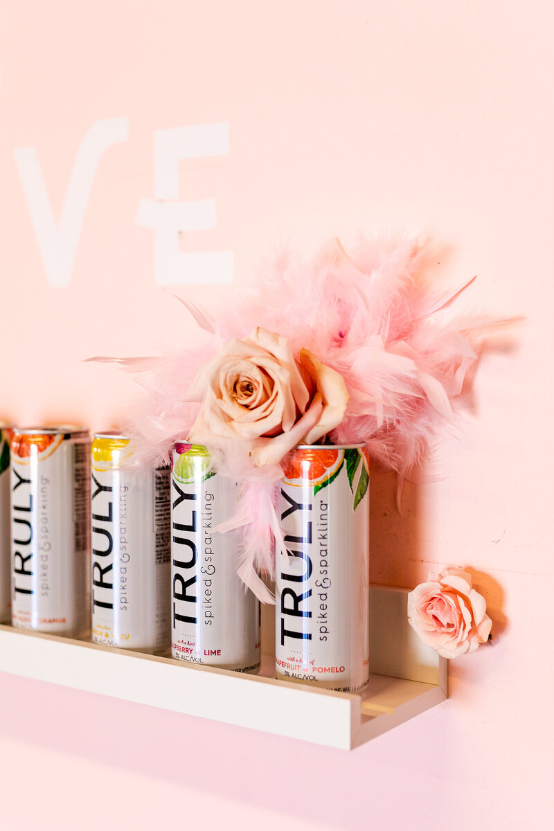 Truly cans with pink feather decoration