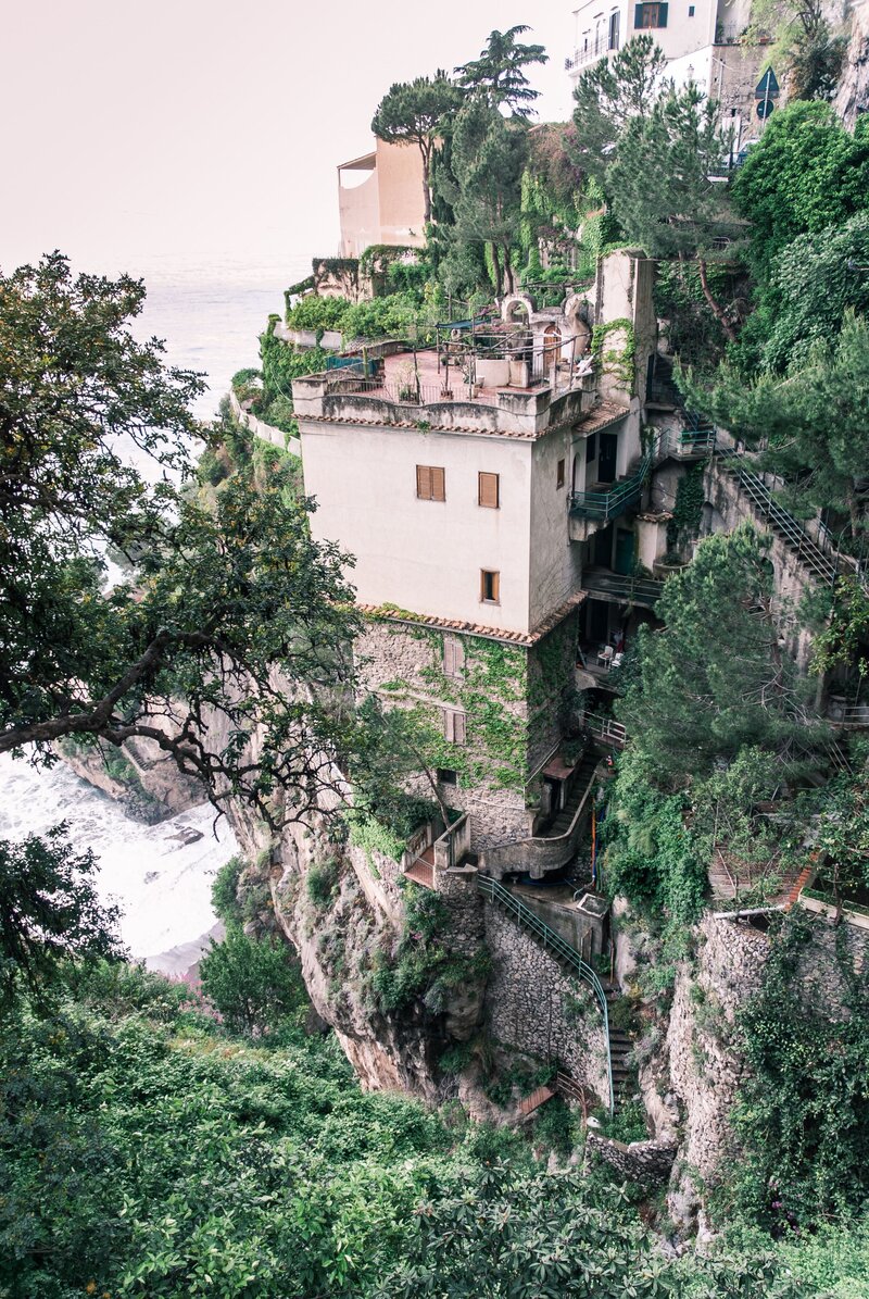 cliffside building surrounded by greenery