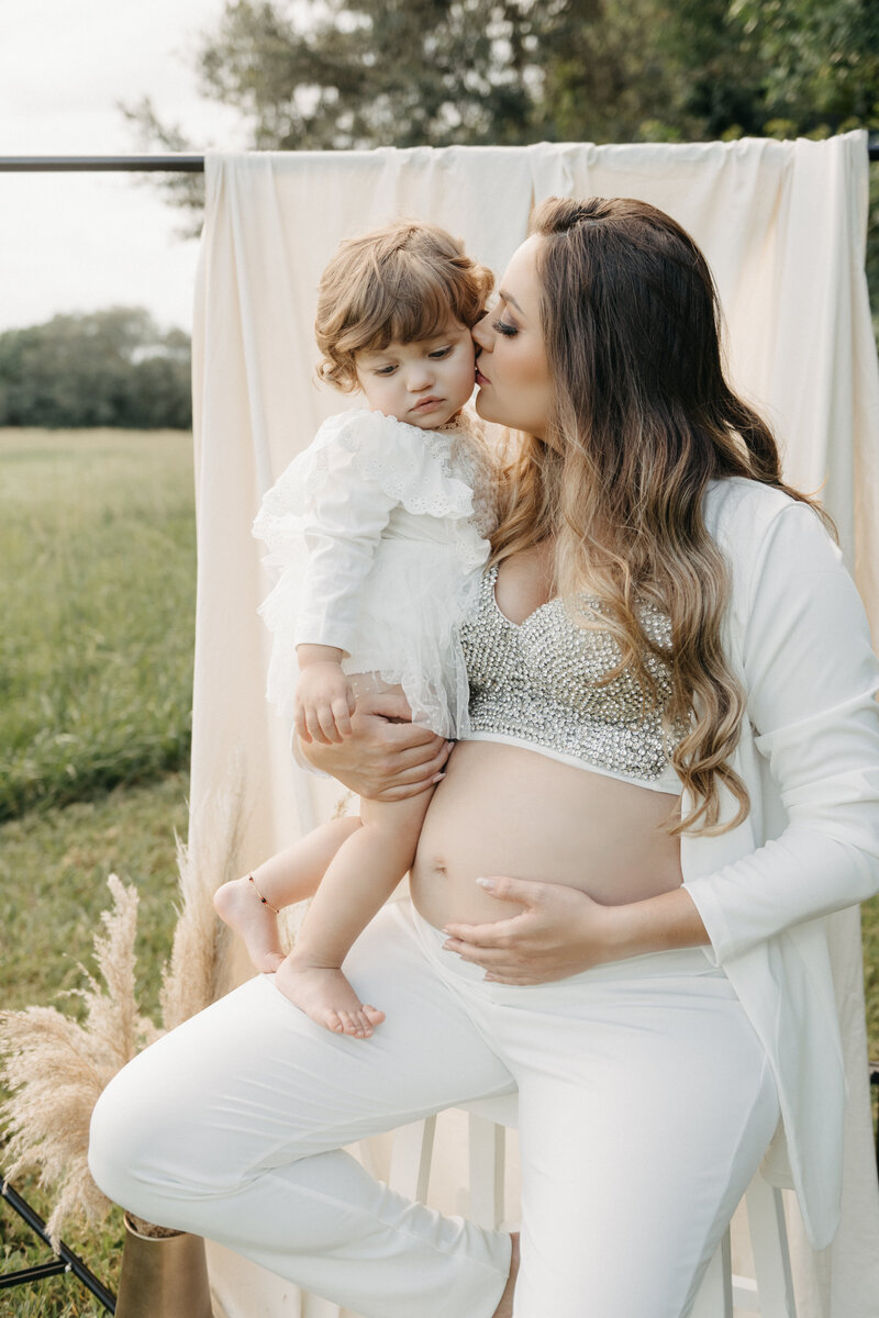 outdoor maternity session with mom holding her baby