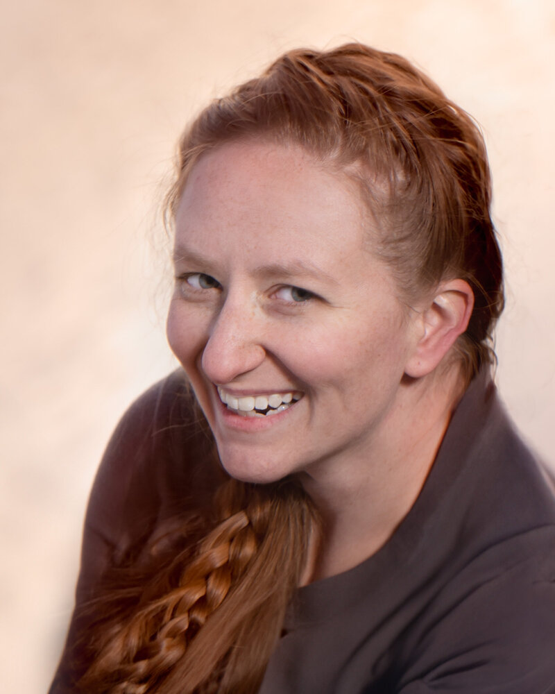 Professional and approachable headshot featuring a photographer specializing in newborn, maternity, and family photography in Overland Park, Kansas. Showcasing creativity and a personalized approach for families in the Kansas City metro area.
