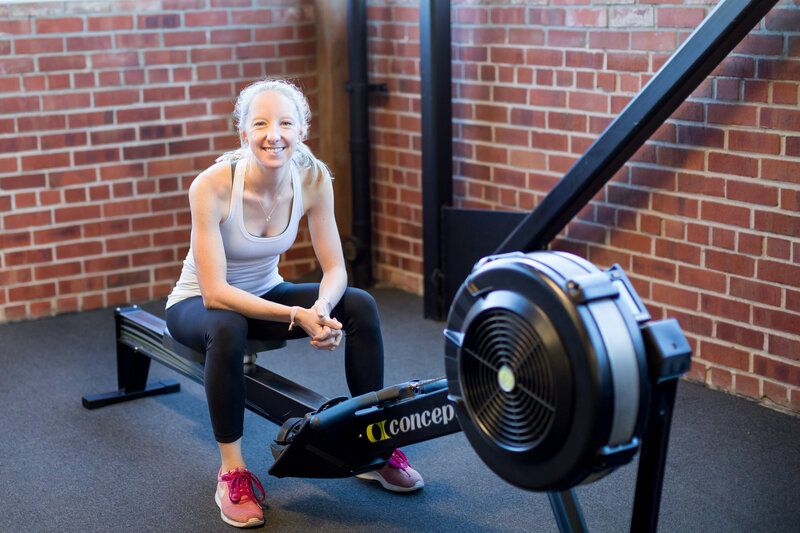 Kristin Hedstrom, an Olympian and erg coach, sitting on the Concept2 rowing machine.