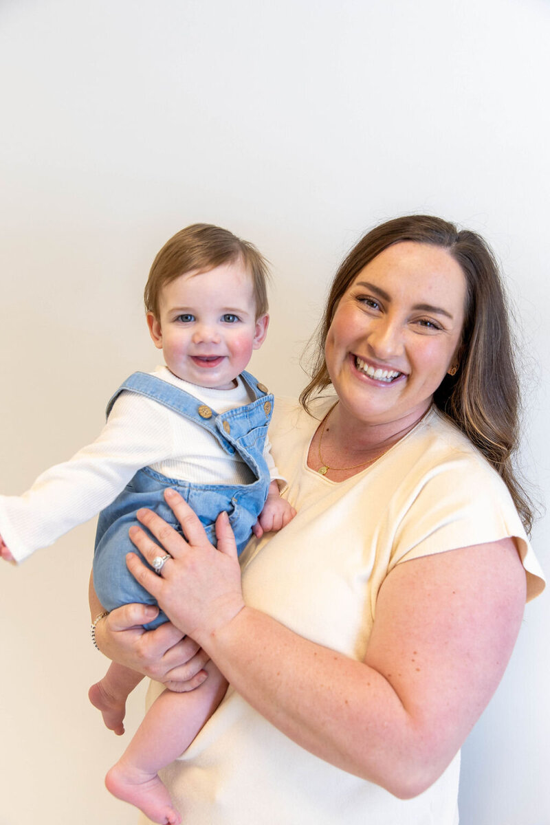 Women smiling as she holds her smiling baby