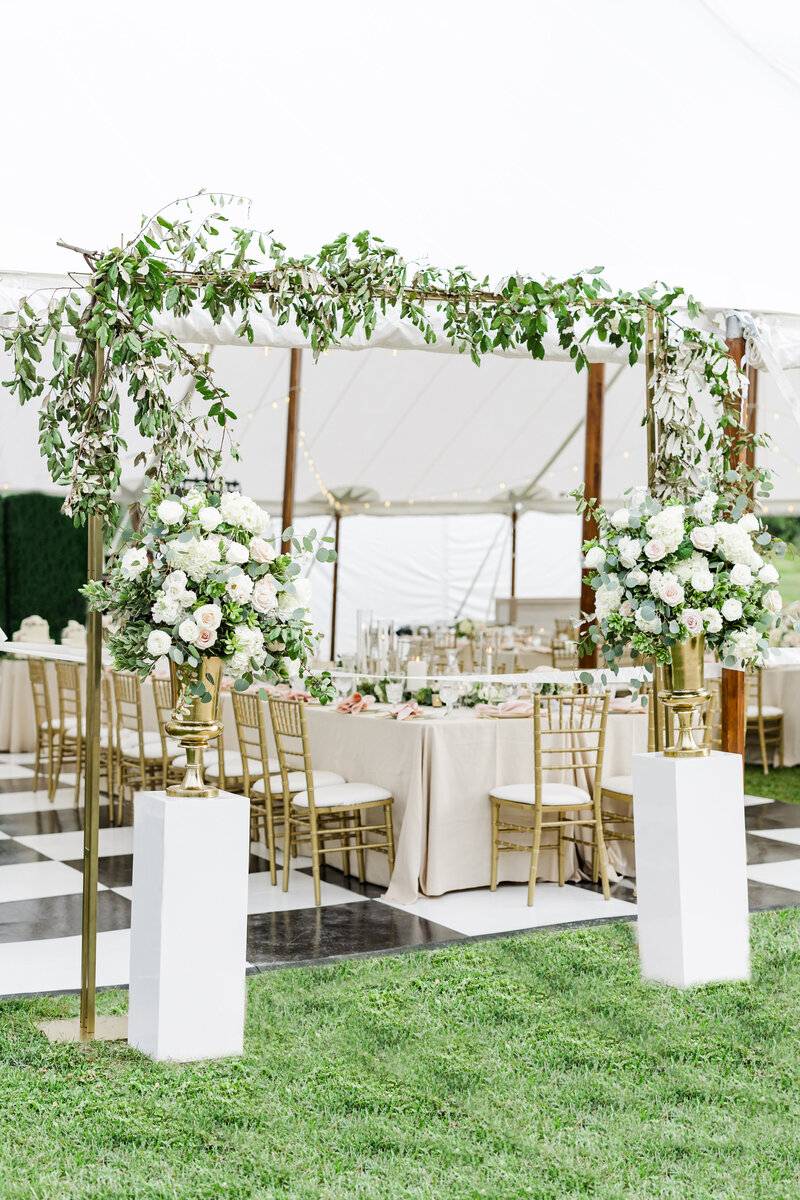 floral arch with a white tent