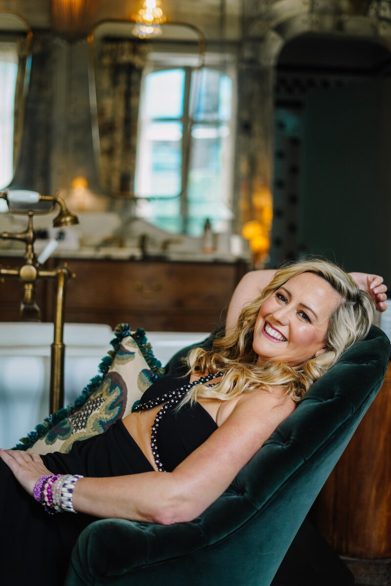 Katie Sol, corporate coach for spiritual entrepreneurs, smiling while laying down, embodying relaxation and positivity.
