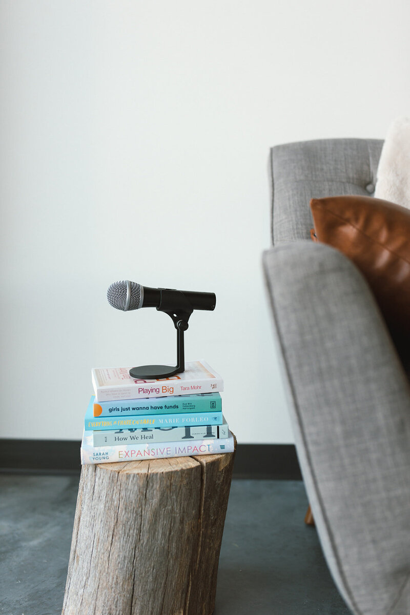 microphone stacked on personal development books highlighting a media training service by a thought leadership expert