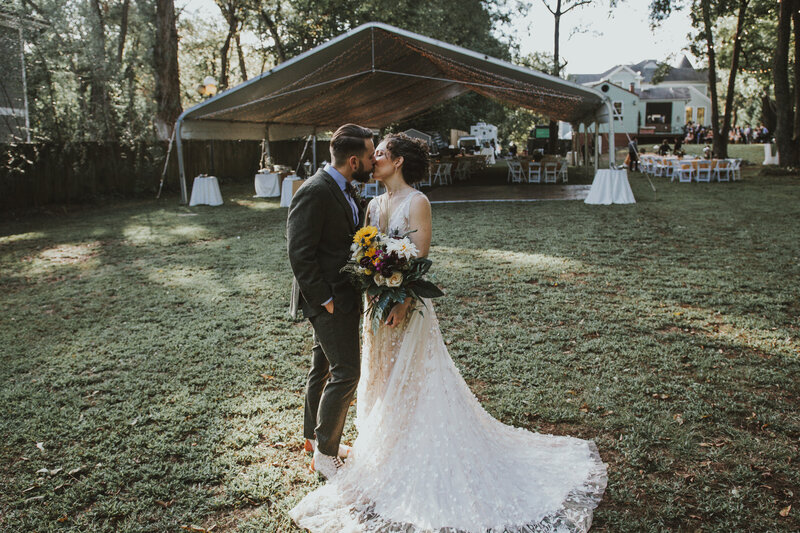 bride and groom kissing in a backyard