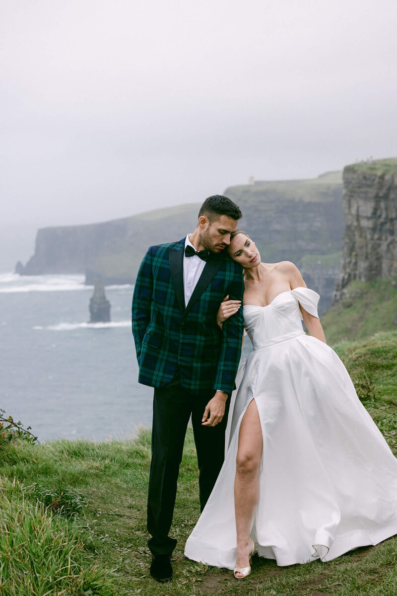 Couple posing for photos during their elopement at the top of the cliffs of Moher in Ireland