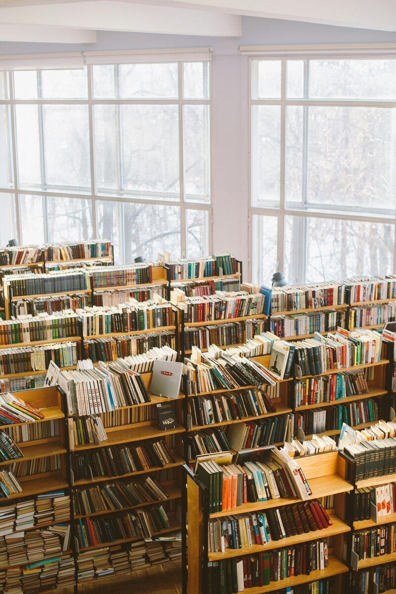 Bright library with half-height bookshelves filled with books, representing a vibrant space for reading, copy editing, and professional proofreading services.