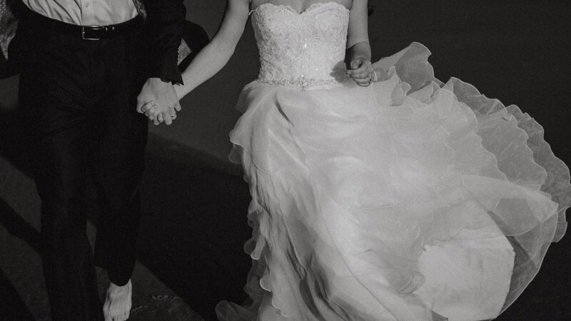 a bride and groom running while holding hands