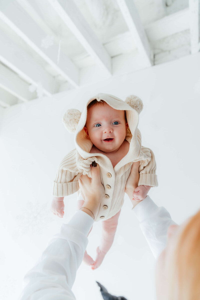 Lifestyle newborn photographer in Northwest Ohio capturing joyful, candid baby portraits with natural light and cozy in-home vibes.