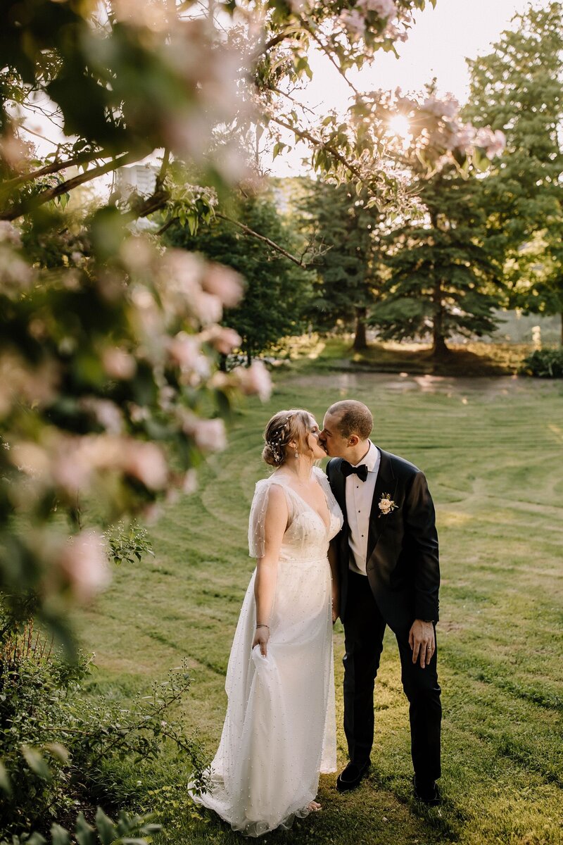 Bride and groom kissing in grassy field