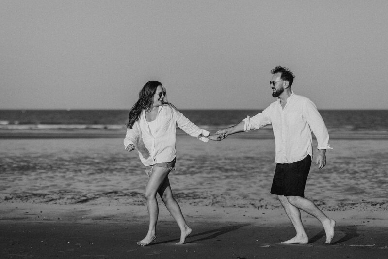 Couple on beach laughing and walking