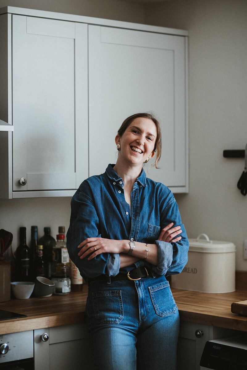 Business coach and copywriter smiles in her kitchen in Oxfordshire
