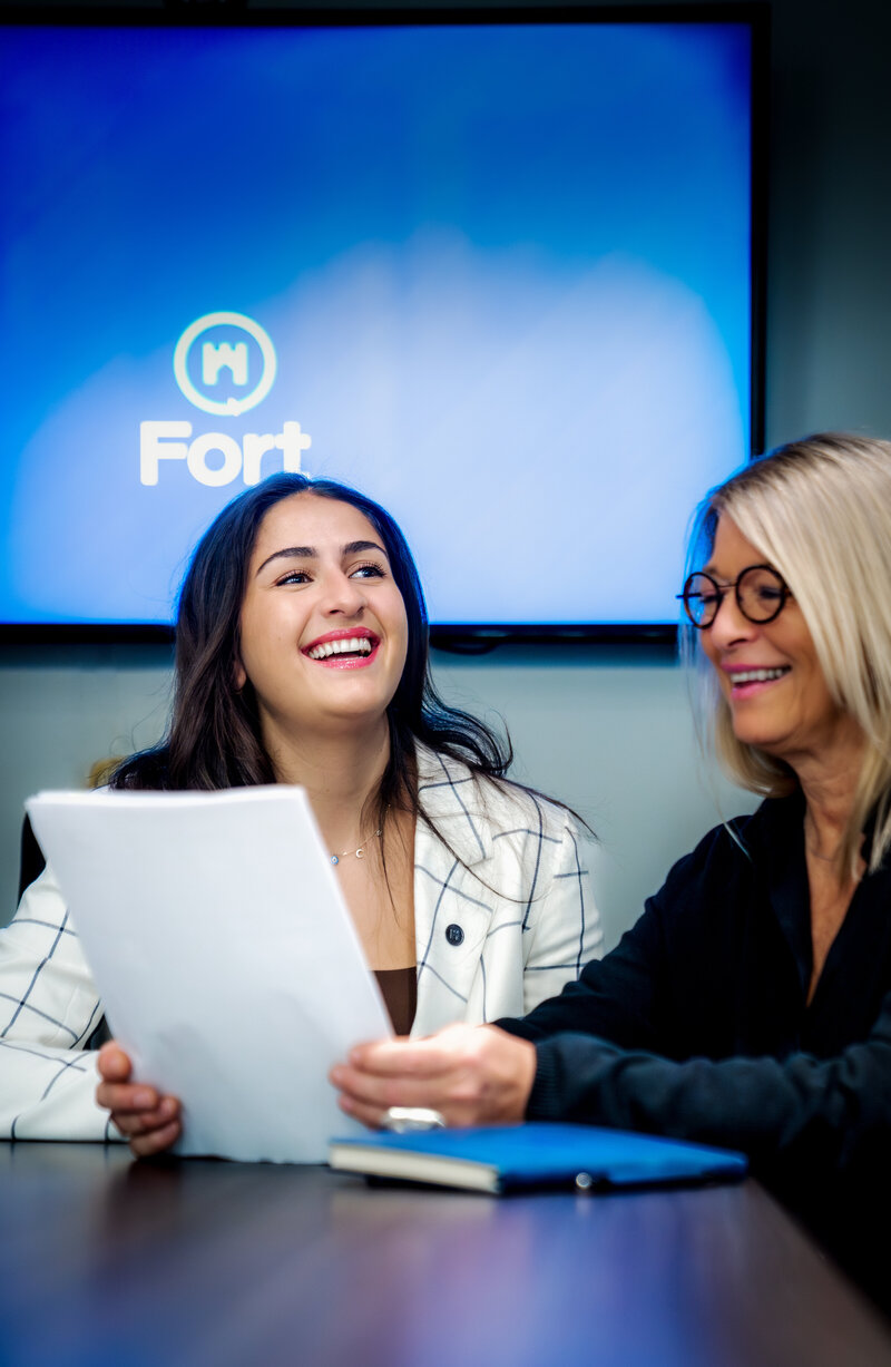 People sitting at a conference table, smiling