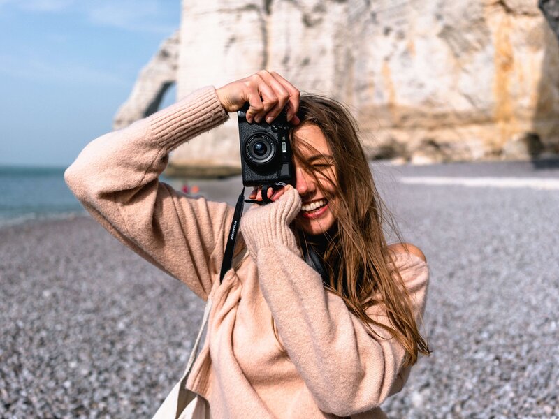 girl with long hair taking a picture with a camera