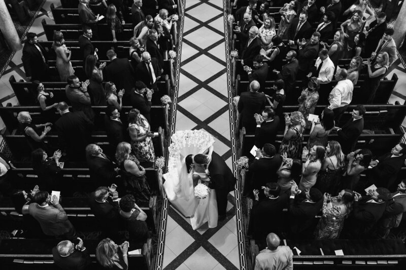 Bride and groom kiss as they walk back down the isle