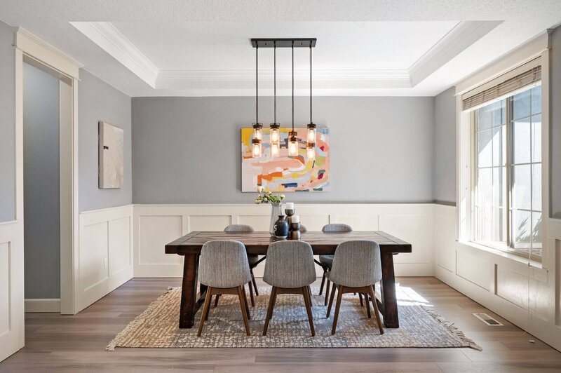 Dining room table with a painting on the wall behind it in a house for sell staged by Portland OR realtor Stephanie Needham.