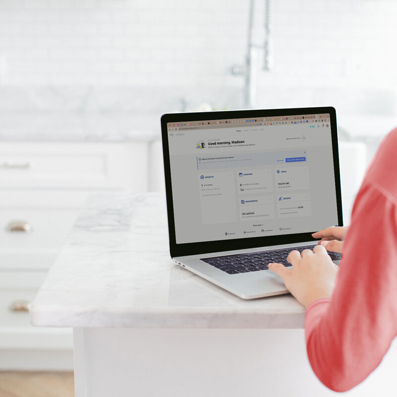 Woman working on a laptop showing HoneyBook