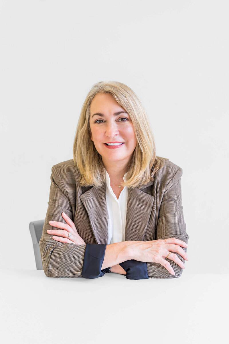 Melissa Greenwell, smiling and sitting at her desk