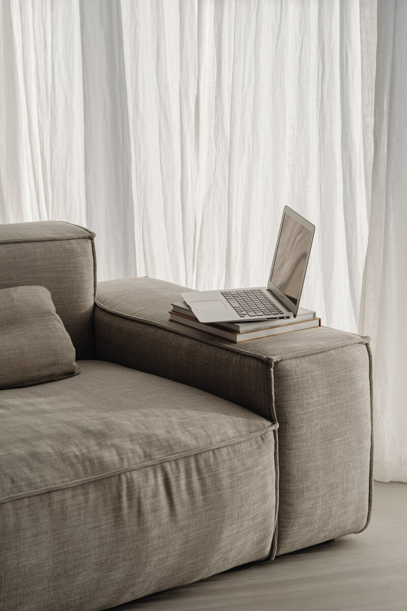 laptop sitting on arm of couch