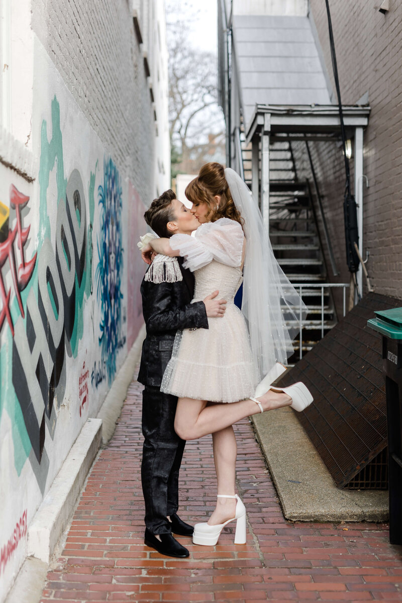 LGBTQ+ couple kissing in alley way
