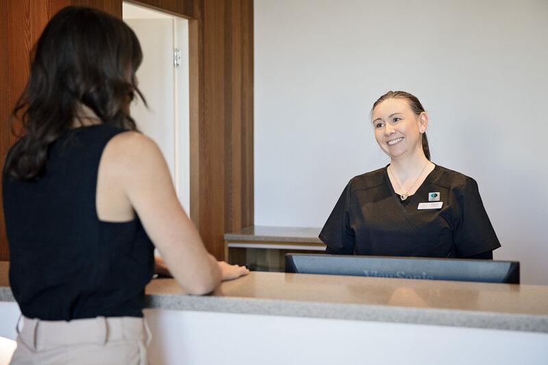 patient discussing procedure at reception of dental surgery