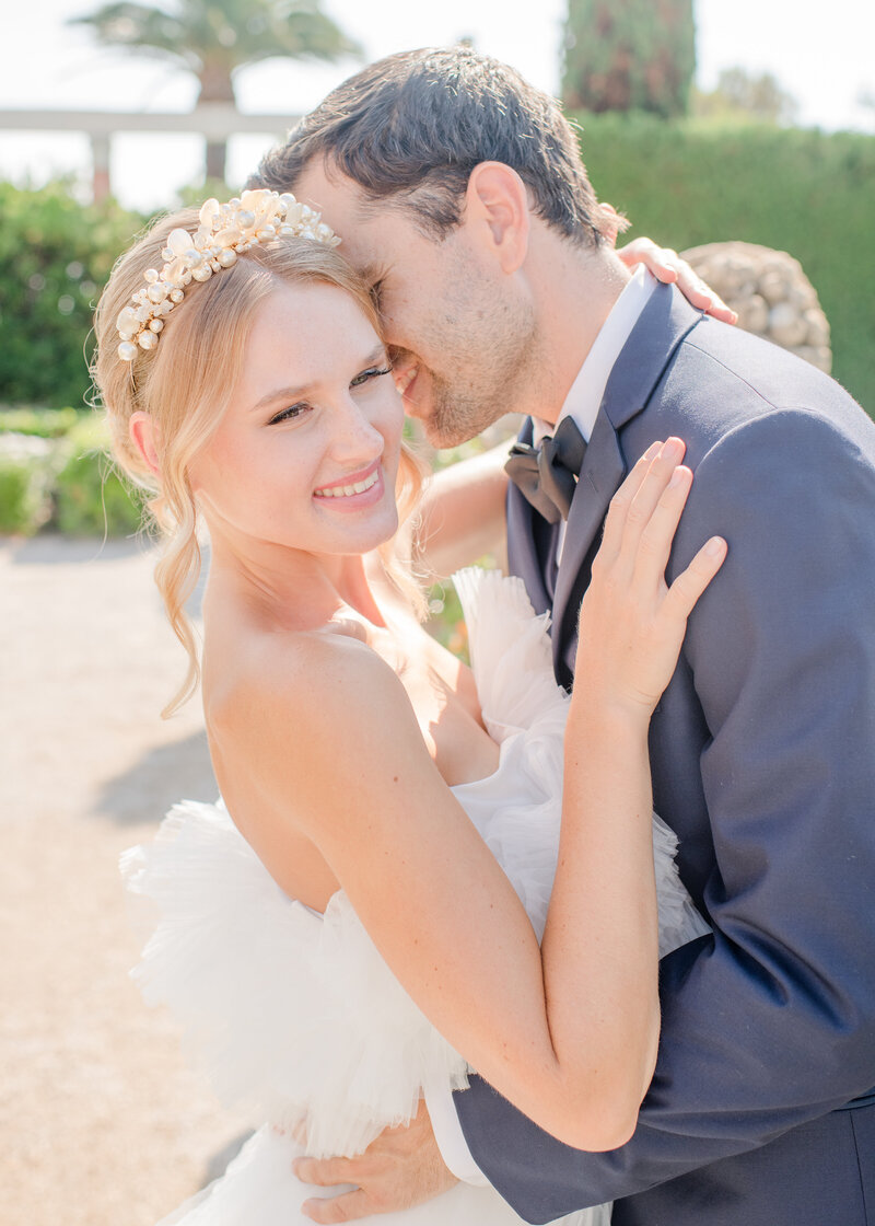 Wedding Photographer, beside a fountain outdoors , a bride smiles, she has a wedding ring and flower bouquet