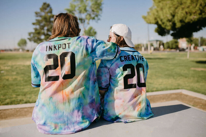 Backs of KP and Jessie with shirts that spell Inkpot Creative.