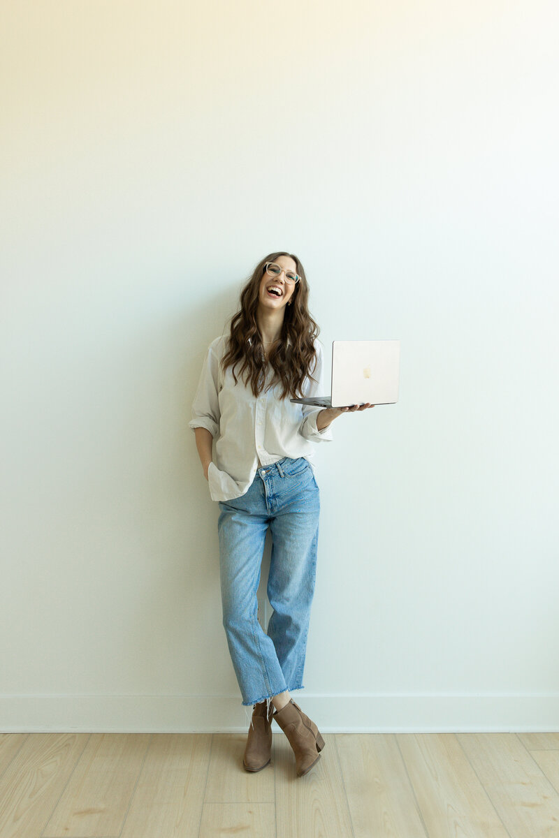 wedding photographer holding laptop laughing