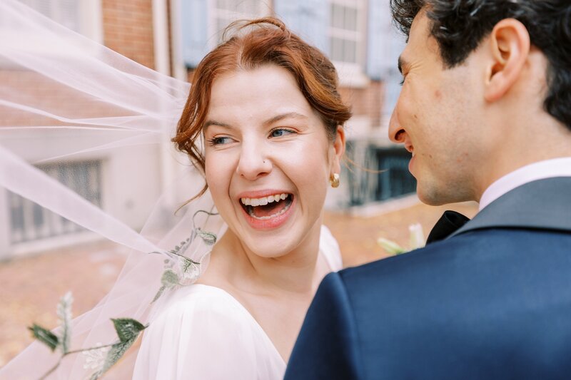 Bride and groom with veil flowing in the wind