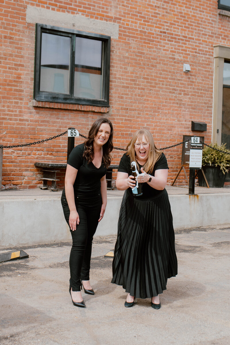 Alberta wedding planners popping champagne