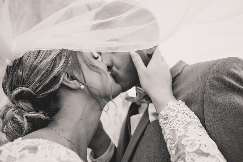 bride and groom share a kiss under veil at intimate wedding in las vegas