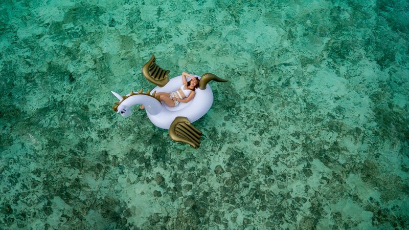 woman relaxing on unicorn inflatable