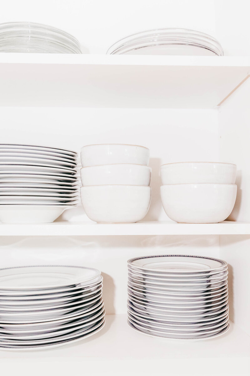 A kitchen cabinet featuring organized plates and bowls