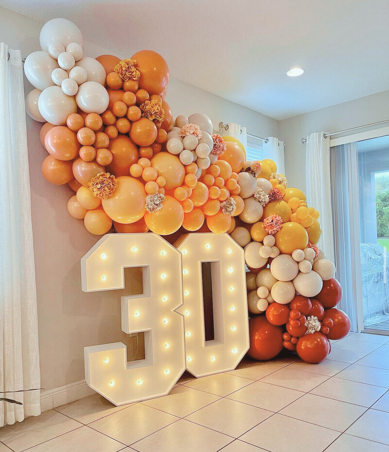 Elegant organic balloon garland with marquee number 30 in an Airbnb in Orlando, by Loononna, LLC.