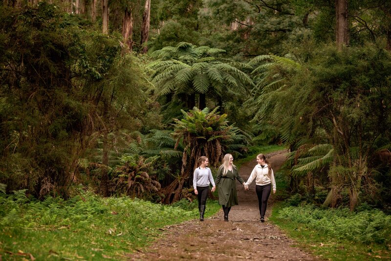 family of four photographed walking treefern lined path at Kallista