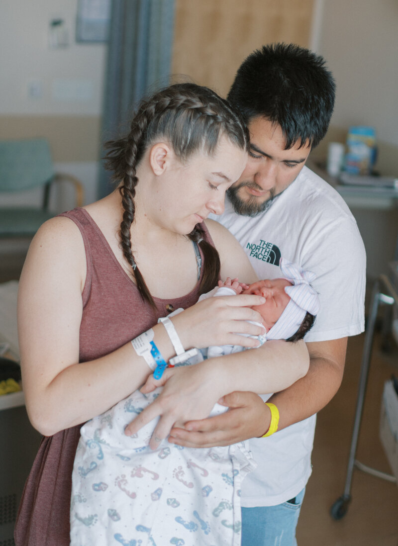 parents holding newborn in the hospital