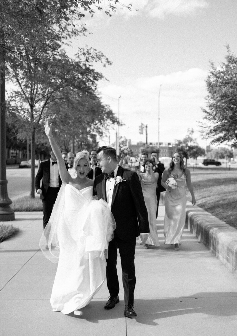 bride and groom standing in front of bridal party cheering by chicago photographer Allison Francois