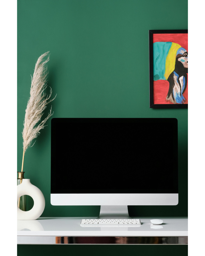 A computer against a dark green wall