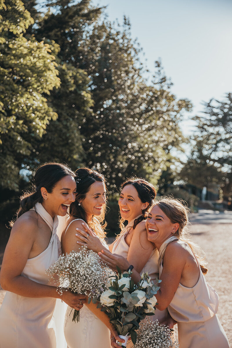 bride and bridesmaids laugh together