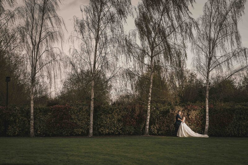 Bride and groom posing in the middle of the forest