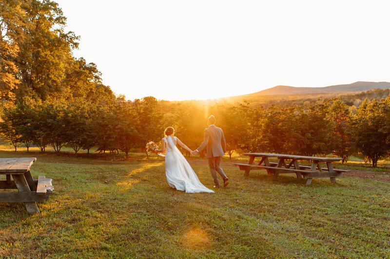 couple running through vineyard on wedding day