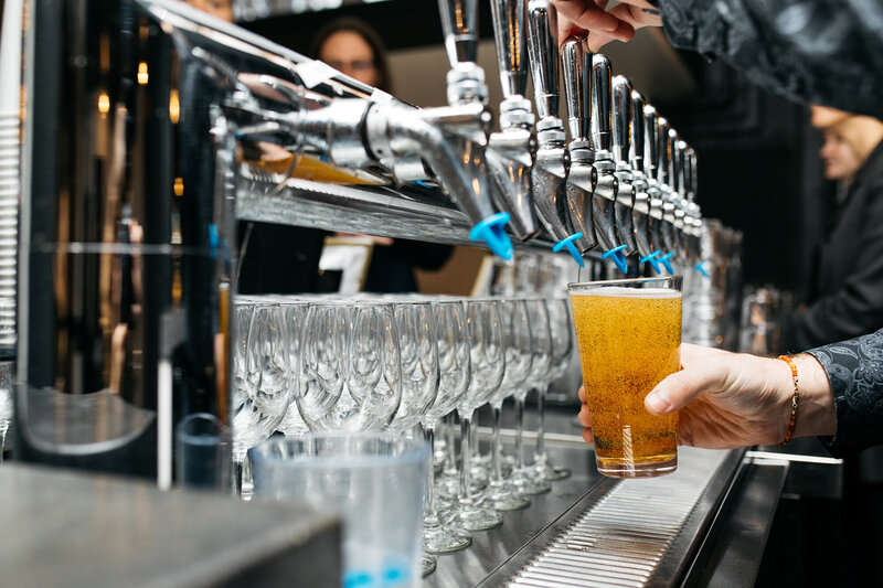 a Person's hand holding a beer glass filling it with a beer from the beer tap