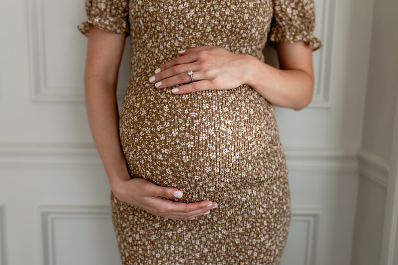 A mother's hands on her pregnant belly.